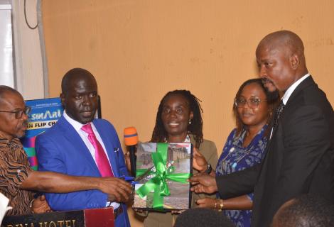 ActionAid Country Director, EPA director, and civil society leaers holding copy of the report as the launch it