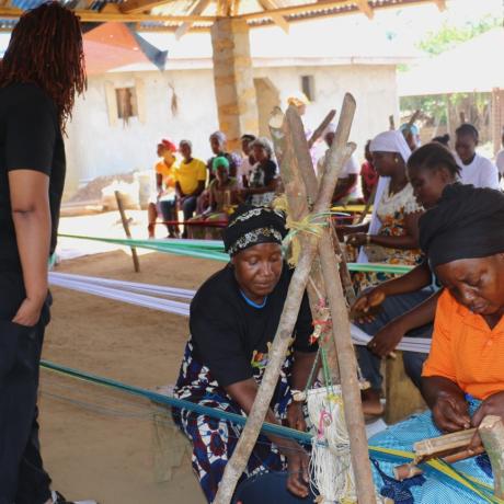 Dwede Tarpeh of the Swedish Embassy and Team mate look on carefully as the women make the Liberian Country clothes