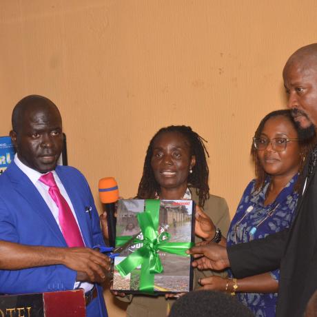 ActionAid Country Director, EPA director, and civil society leaers holding copy of the report as the launch it