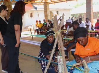Dwede Tarpeh of the Swedish Embassy and Team mate look on carefully as the women make the Liberian Country clothes